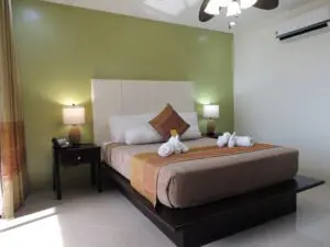 Cozy bedroom with a neatly made bed and warm lighting.