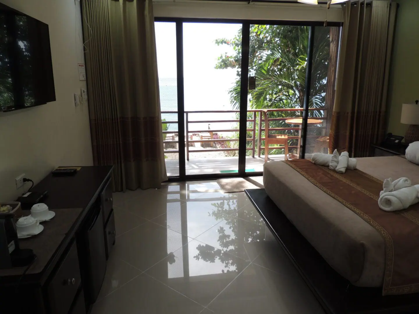 Bright hotel room with balcony and ocean view.