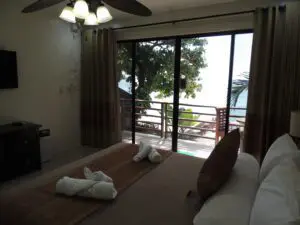 Cozy bedroom with balcony view and towel art on the bed.