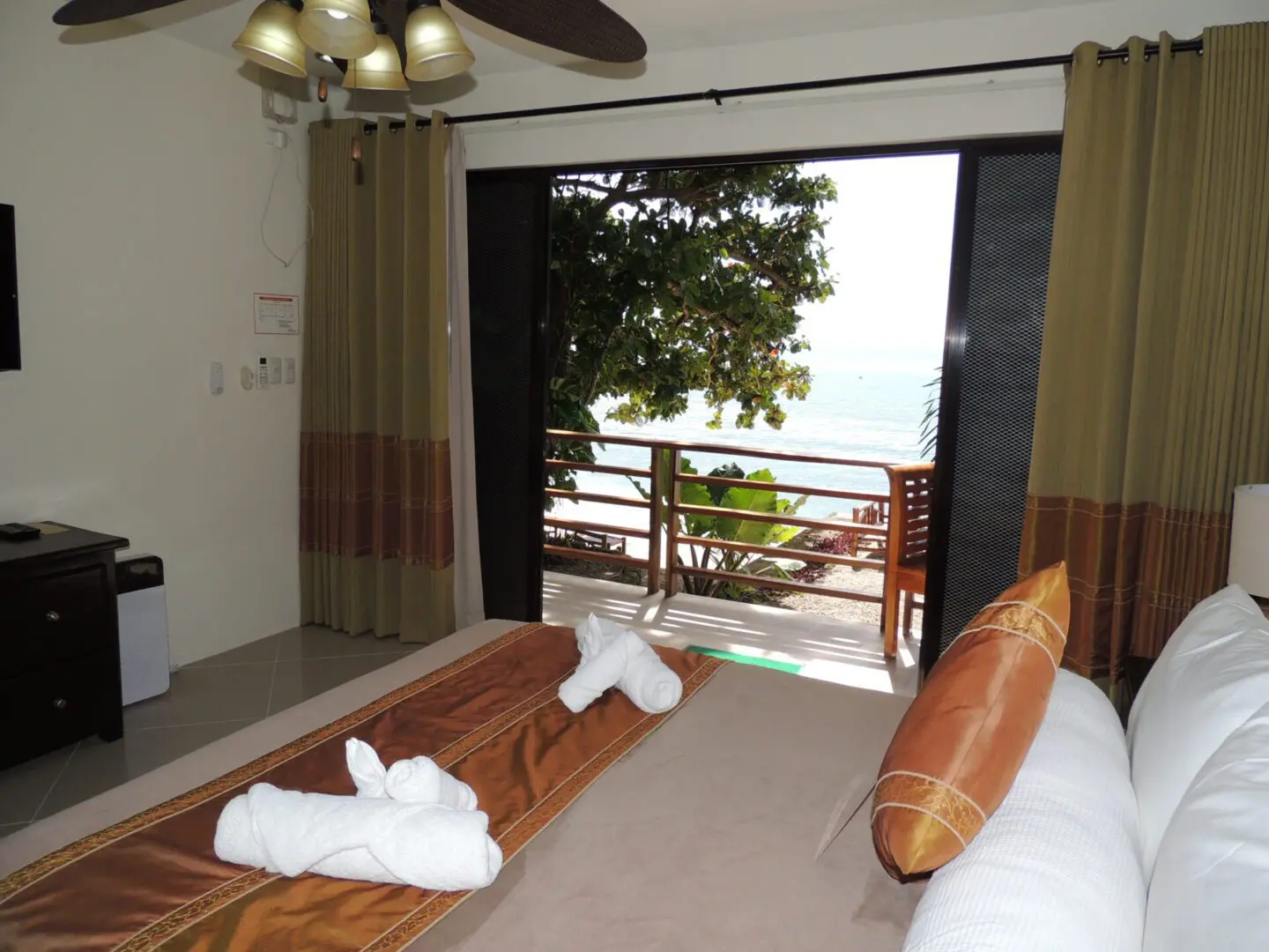 Cozy bedroom with a balcony overlooking a waterfront view.