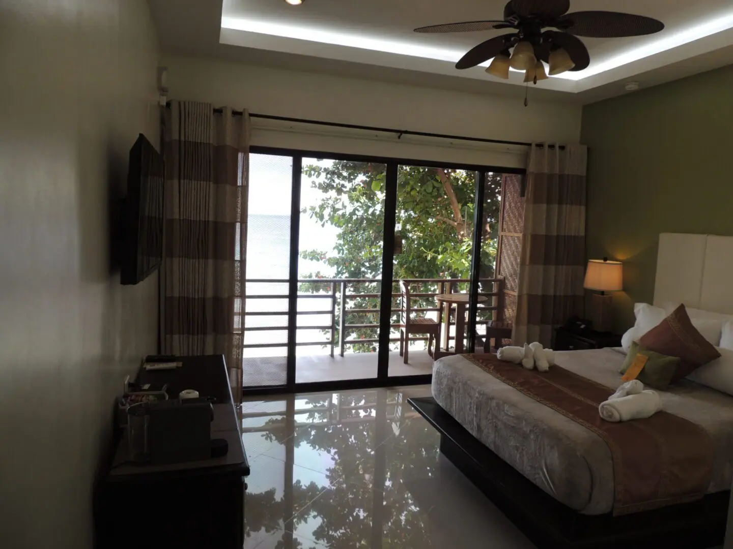 Cozy bedroom with balcony view and warm lighting.
