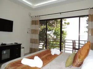 Cozy bedroom with a balcony and natural light.
