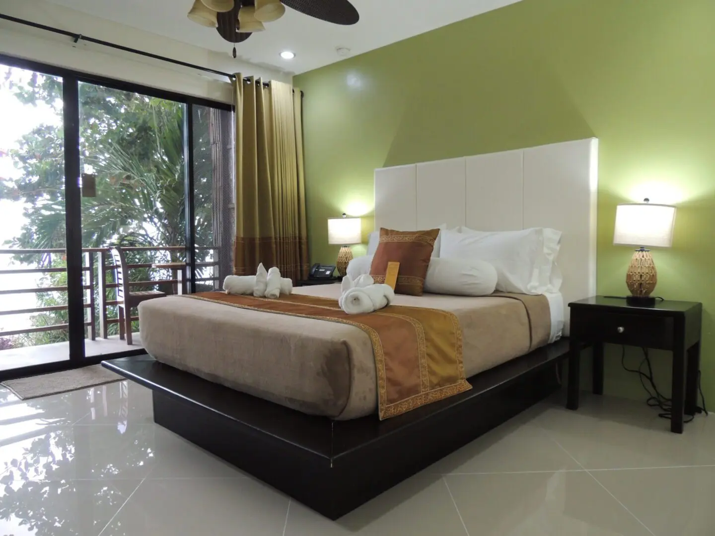 Modern bedroom with green accent wall and large sliding glass door.