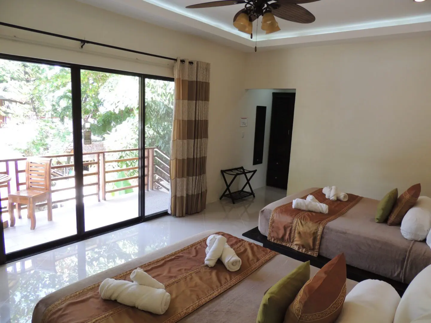 Cozy bedroom with twin beds and sliding glass doors opening to a balcony.